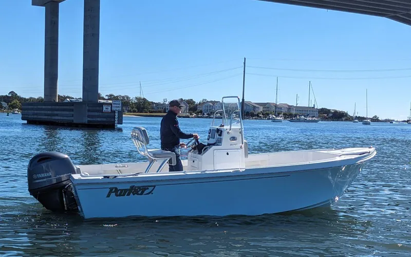 Slide: The Image of 2024 Parker 1801 Center Console boat on water, under a bridge, with a Yamaha outboard motor. - 3