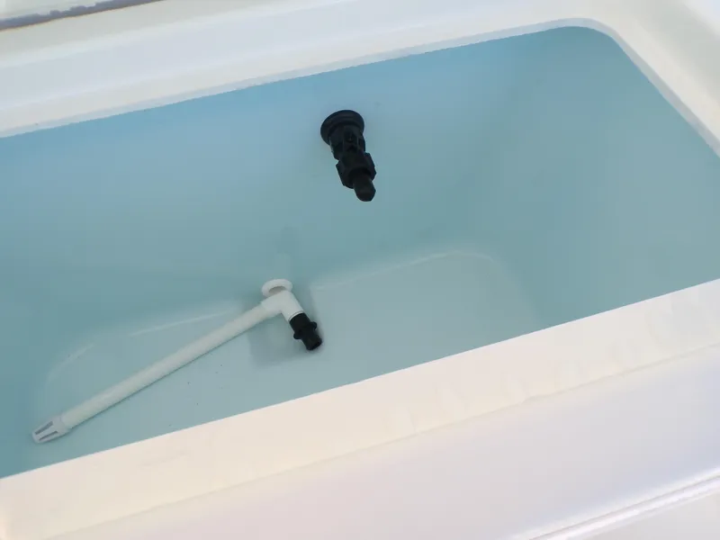 Slide: The Image of Livewell interior of 2024 Parker 1801 Center Console boat, featuring drain and water inlet. - 31