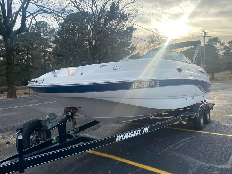 Slide: The Image of 2005 Chaparral Sunesta 254 boat on trailer in parking lot, sun setting in background. - 10