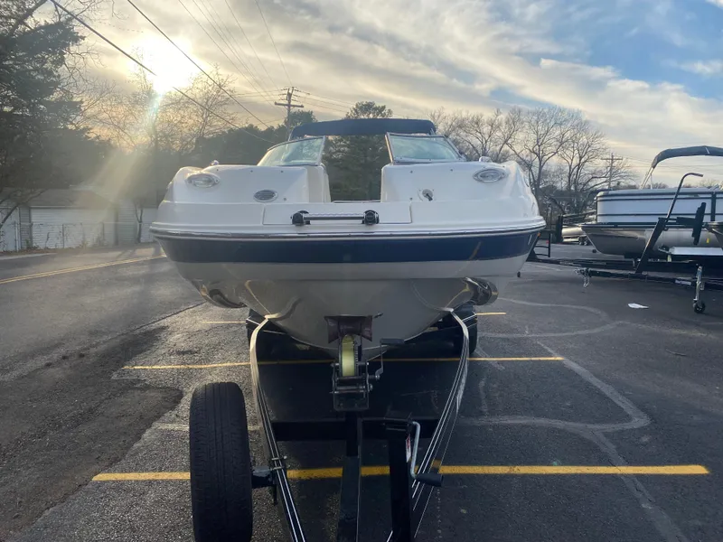 Slide: The Image of 2005 Chaparral Sunesta 254 boat on trailer, parked in a lot under a cloudy sky. - 14