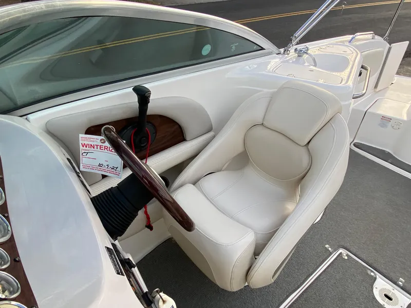 Slide: The Image of 2005 Chaparral Sunesta 254 boat cockpit with white captain's chair and steering wheel. - 16