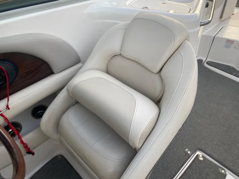 Slide: The Image of 2005 Chaparral Sunesta 254 boat seat with beige upholstery and steering wheel detail. - 21