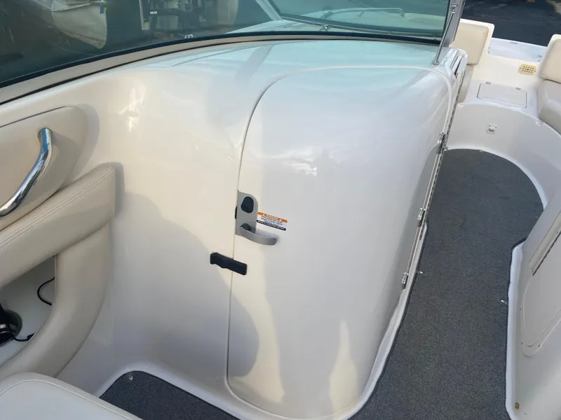 Slide: The Image of 2005 Chaparral Sunesta 254 boat interior with white seating and storage compartment. - 22