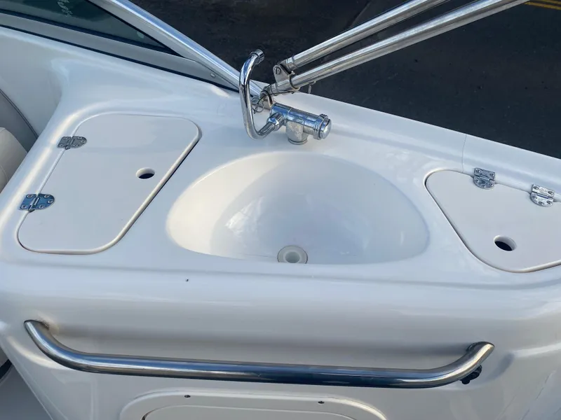 Slide: The Image of 2005 Chaparral Sunesta 254 boat sink with faucet and storage compartments. - 35