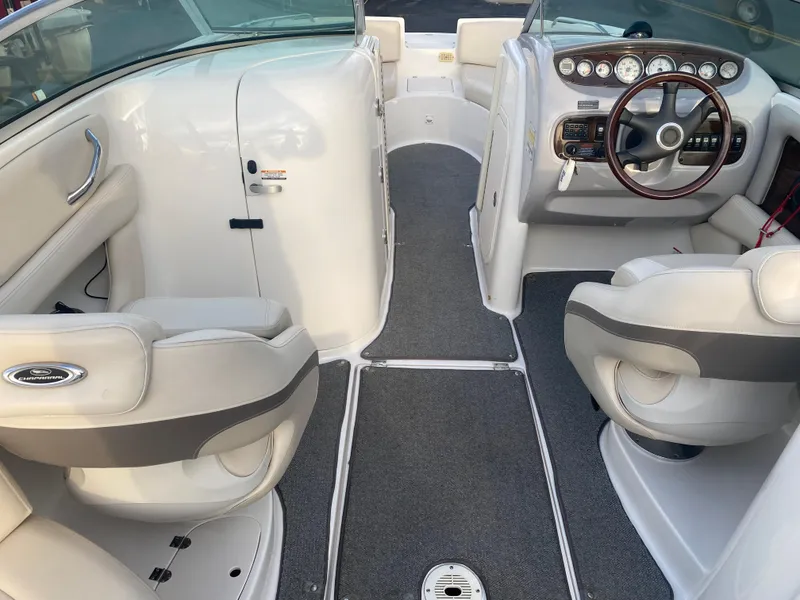 Slide: The Image of 2005 Chaparral Sunesta 254 boat interior with white seating and modern dashboard. - 36