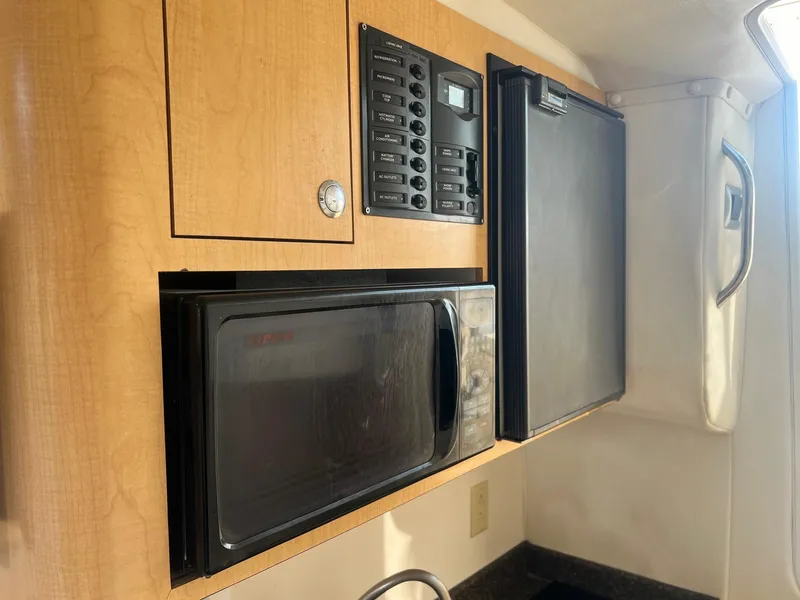 Slide: The Image of 2005 World Cat 320EC interior with microwave, control panel, and refrigerator. - 10