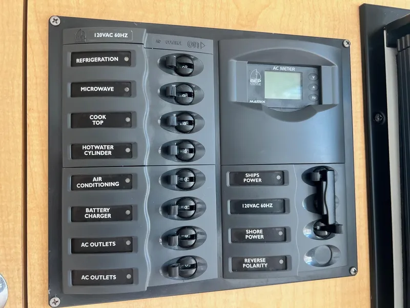 Slide: The Image of Electrical control panel on a 2005 World Cat 320EC boat, featuring various switches and an AC meter. - 11