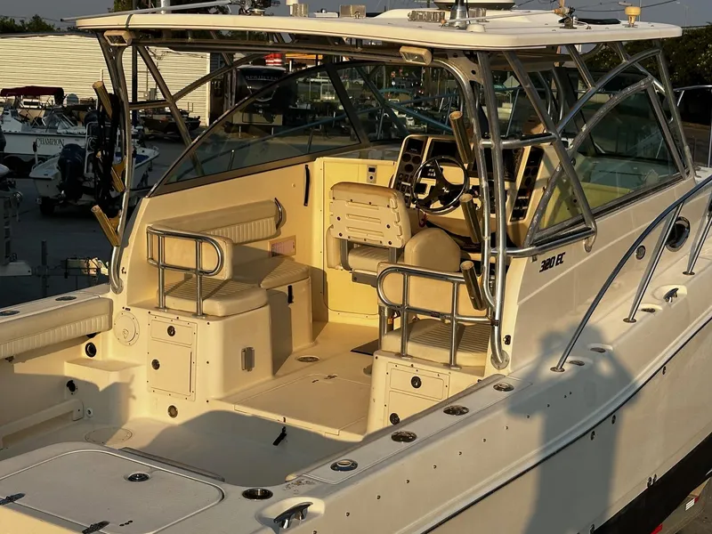 Slide: The Image of 2005 World Cat 320EC boat interior with seating and steering area, docked in sunlight. - 14