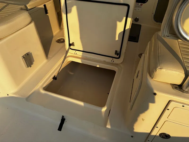 Slide: The Image of Open storage compartment on a 2005 World Cat 320EC boat, featuring beige interior. - 17