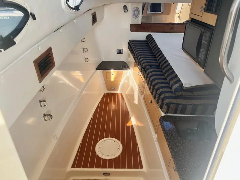 Slide: The Image of 2005 World Cat 320EC cabin interior with striped seating and wood flooring. - 21