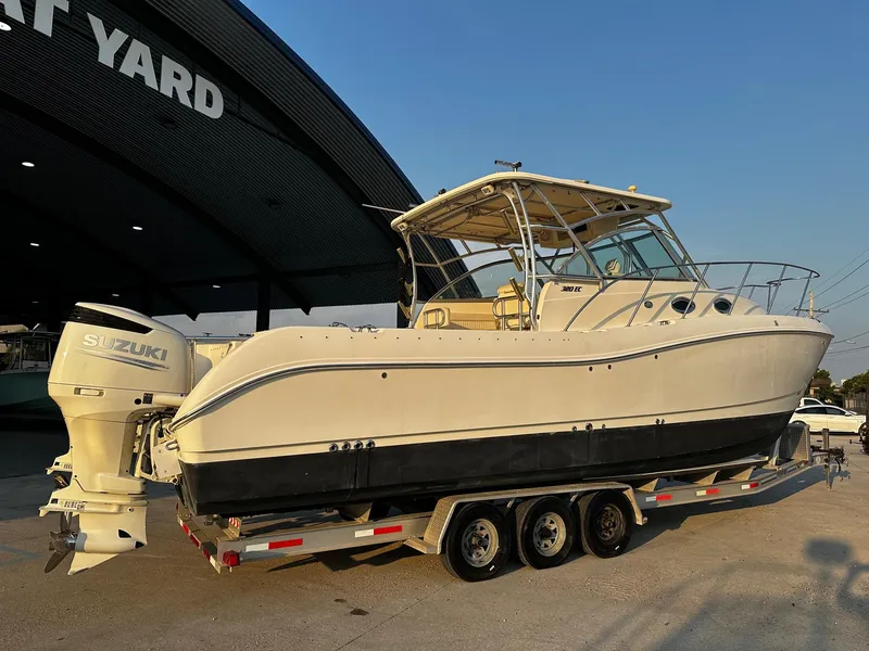 Slide: The Image of 2005 World Cat 320EC boat on trailer, parked at a boat yard, with Suzuki engines. - 4