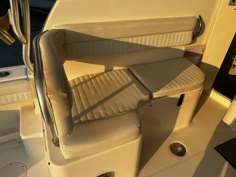 Slide: The Image of 2005 World Cat 320EC boat interior seating with beige upholstery and metal railing. - 8