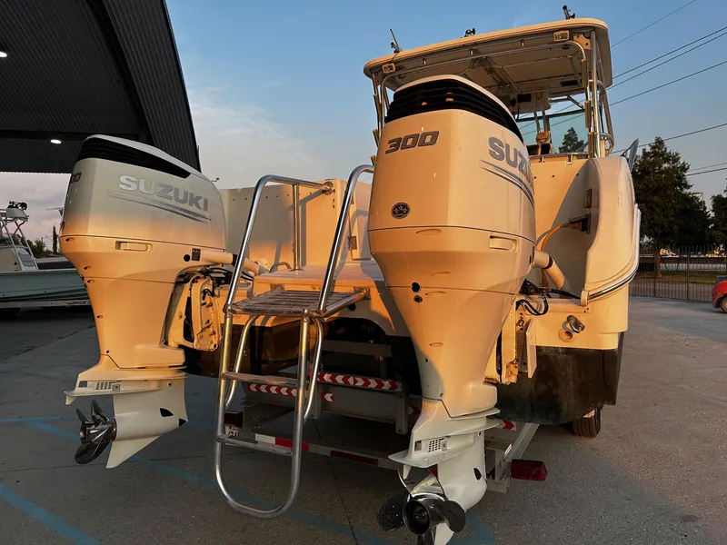 Slide: The Image of 2005 World Cat 320EC boat with dual Suzuki 300 engines, docked at sunset. - 9