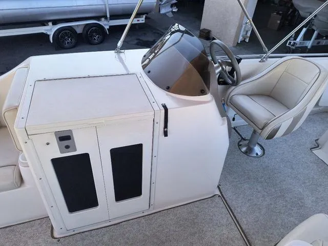 Slide: The Image of 1998 Ebbtide 2300 Mystique Deck Boat interior with helm and seating. - 10