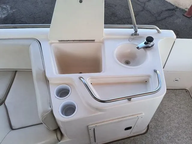 Slide: The Image of 1998 Ebbtide 2300 Mystique Deck Boat interior with sink and cup holders. - 12