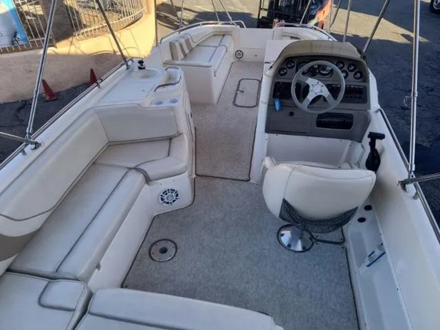 Slide: The Image of 1998 Ebbtide 2300 Mystique Deck Boat interior with seating and steering console. - 19