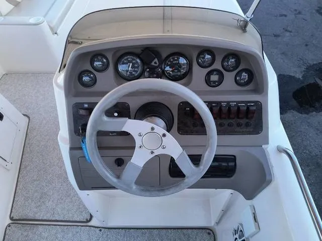Slide: The Image of 1998 Ebbtide 2300 Mystique Deck Boat dashboard with steering wheel and gauges. - 20