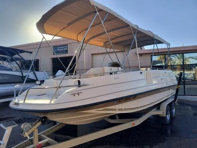 Slide: The Image of 1998 Ebbtide 2300 Mystique Deck Boat on trailer with canopy, parked outdoors. - 3