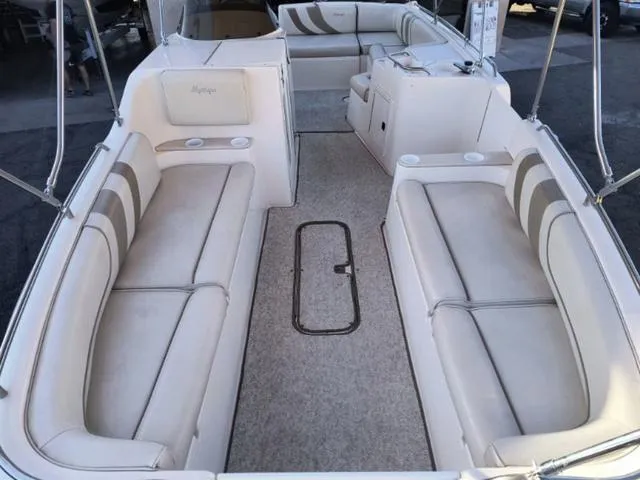 Slide: The Image of 1998 Ebbtide 2300 Mystique Deck Boat with spacious seating and beige upholstery. - 8
