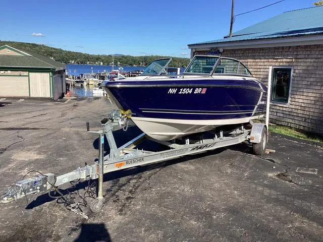 Slide: The Image of 2012 Monterey Sport Boat 184FS on trailer, parked near waterfront buildings. - 1