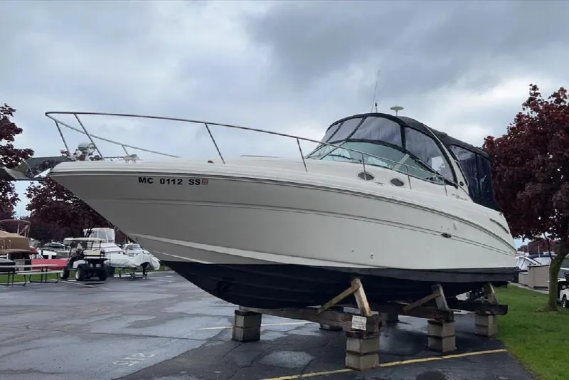 Slide: The Image of 2002 Sea Ray 300 Sundancer boat on stands in a marina setting. - 1