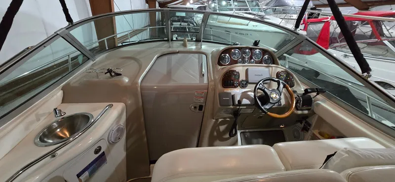 Slide: The Image of 2002 Sea Ray 300 Sundancer cockpit with steering wheel and control panel. - 16