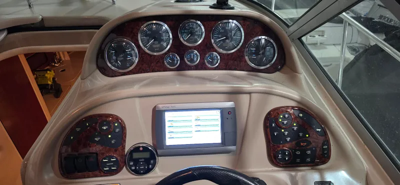 Slide: The Image of Dashboard of a 2002 Sea Ray 300 Sundancer boat with gauges and navigation screen. - 18