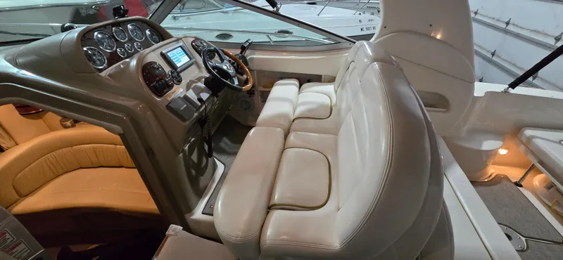 Slide: The Image of 2002 Sea Ray 300 Sundancer cockpit with beige seating and control panel. - 19