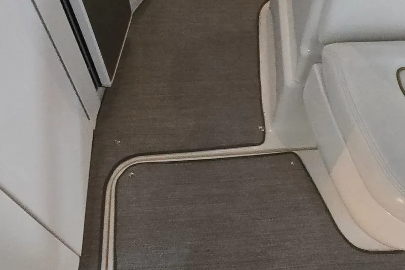 Slide: The Image of Interior view of 2002 Sea Ray 300 Sundancer boat with carpeted flooring. - 23