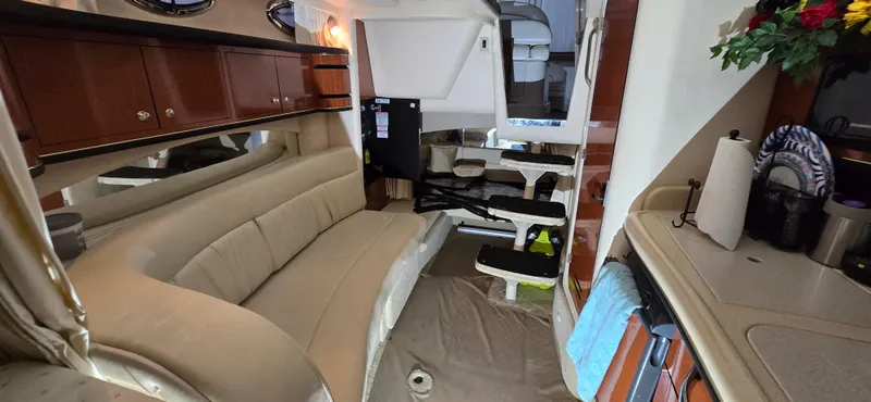 Slide: The Image of Interior of a 2002 Sea Ray 300 Sundancer yacht with beige seating and kitchenette. - 27