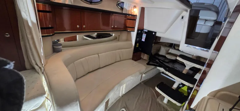 Slide: The Image of Interior of 2002 Sea Ray 300 Sundancer with beige seating and wooden cabinets. - 30
