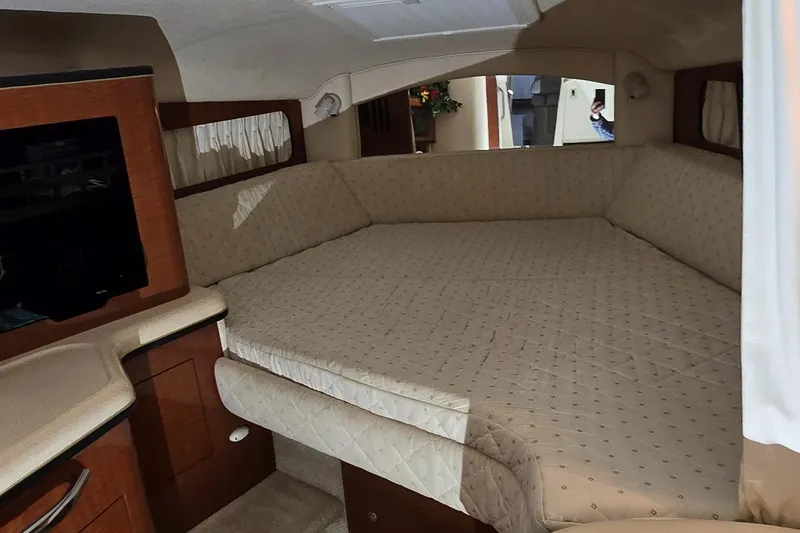Slide: The Image of Interior cabin of 2002 Sea Ray 300 Sundancer with spacious bed and wooden cabinetry. - 32