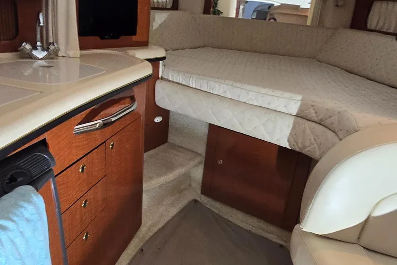 Slide: The Image of Interior of 2002 Sea Ray 300 Sundancer with cozy bed and wooden cabinetry. - 33