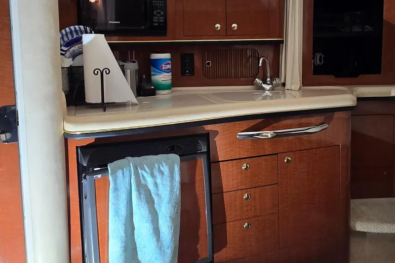 Slide: The Image of 2002 Sea Ray 300 Sundancer kitchen area with wooden cabinets and countertop. - 34
