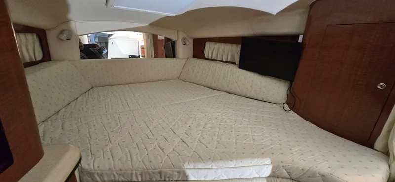 Slide: The Image of 2002 Sea Ray 300 Sundancer cabin interior with beige upholstery and wood accents. - 35