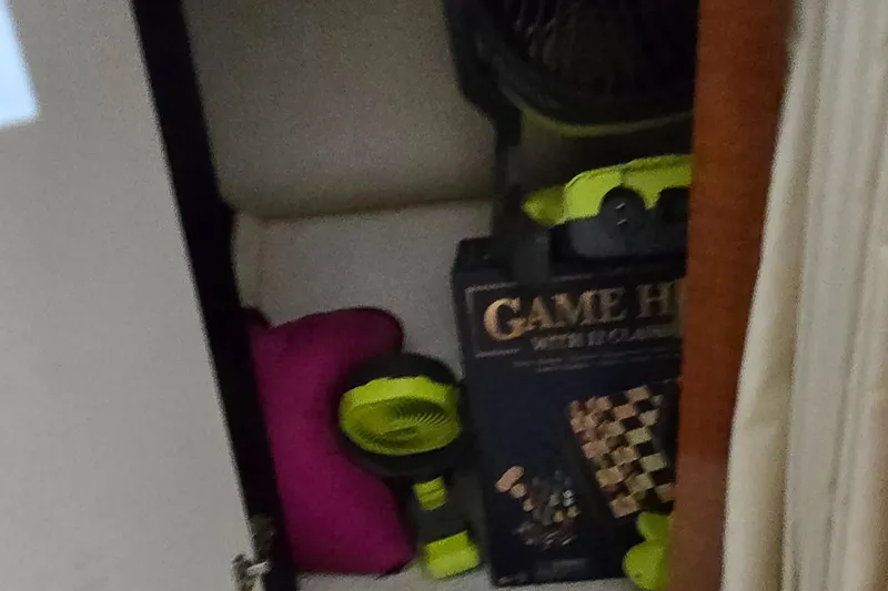 Slide: The Image of Storage compartment in a 2002 Sea Ray 300 Sundancer with games and equipment. - 36