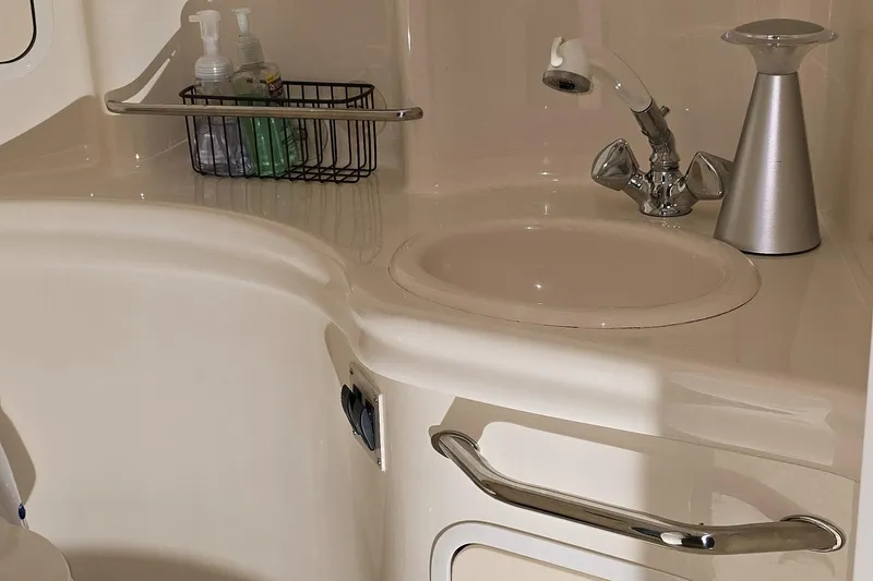 Slide: The Image of Bathroom sink area in 2002 Sea Ray 300 Sundancer yacht, featuring faucet and toiletries. - 39