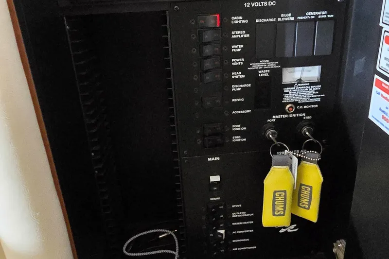 Slide: The Image of Control panel of a 2002 Sea Ray 300 Sundancer boat with labeled switches and keys. - 42