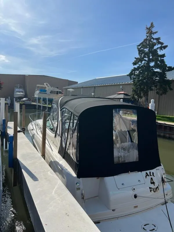 Slide: The Image of 2002 Sea Ray 300 Sundancer docked, featuring a black canopy and white hull. - 5