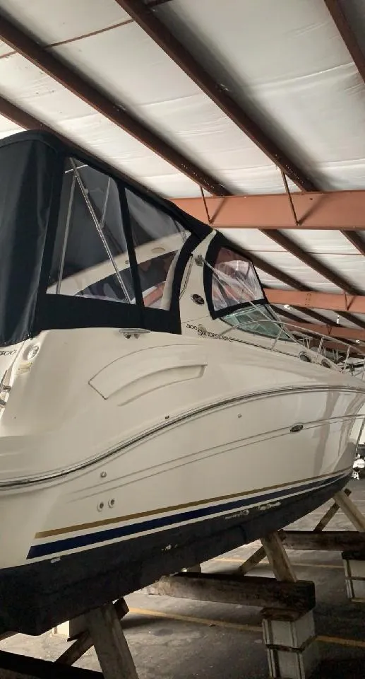 Slide: The Image of 2002 Sea Ray 300 Sundancer boat in storage, covered and elevated. - 6