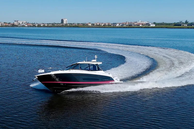 Slide: The Image of 2021 Regal 36 XO boat cruising on a calm lake, creating a smooth wake. - 10