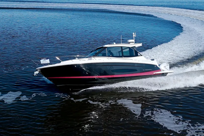 Slide: The Image of 2021 Regal 36 XO boat cruising on open water, creating a dynamic wake. - 11