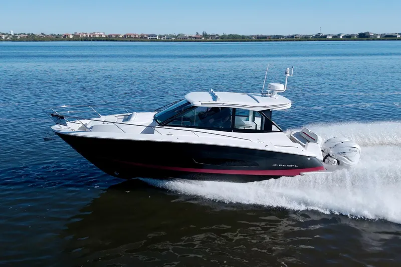 Slide: The Image of 2021 Regal 36 XO boat cruising on a calm blue lake. - 13