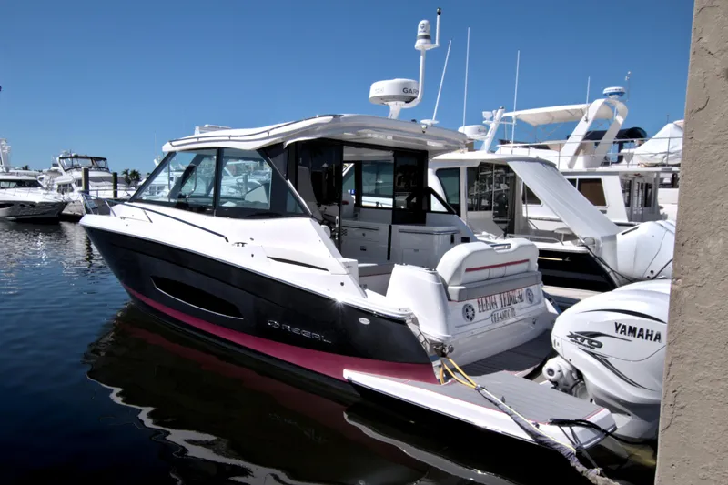 Slide: The Image of 2021 Regal 36 XO boat docked, featuring sleek design and Yamaha outboard engines. - 14