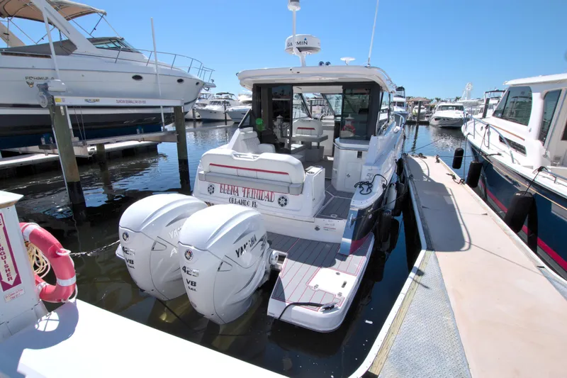 Slide: The Image of 2021 Regal 36 XO boat docked with twin Yamaha outboard engines. - 15