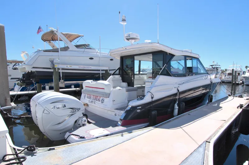 Slide: The Image of 2021 Regal 36 XO boat docked at marina, featuring sleek design and powerful outboard engines. - 16