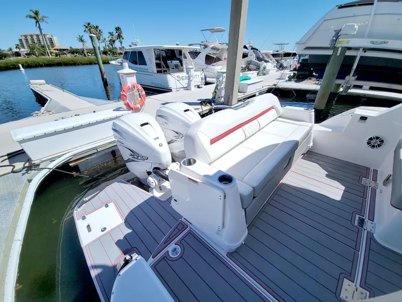 Slide: The Image of 2021 Regal 36 XO boat docked, featuring spacious seating and dual outboard engines. - 20