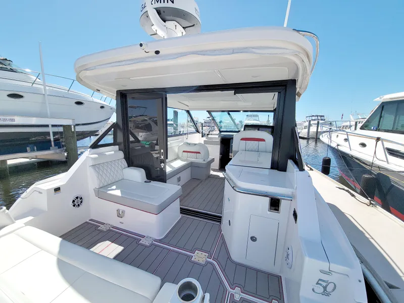 Slide: The Image of 2021 Regal 36 XO yacht interior with modern seating and sleek design at a marina. - 21