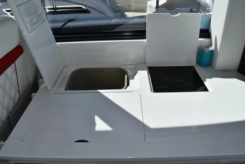Slide: The Image of 2021 Regal 36 XO yacht kitchenette with sink and stove, featuring sleek white design. - 28
