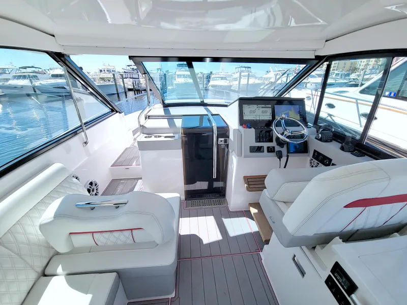 Slide: The Image of 2021 Regal 36 XO yacht interior with modern helm, plush seating, and marina view. - 31